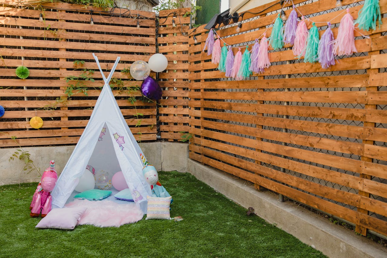 services-02 Charming children's party setup with colorful decorations and a tent in a garden setting.